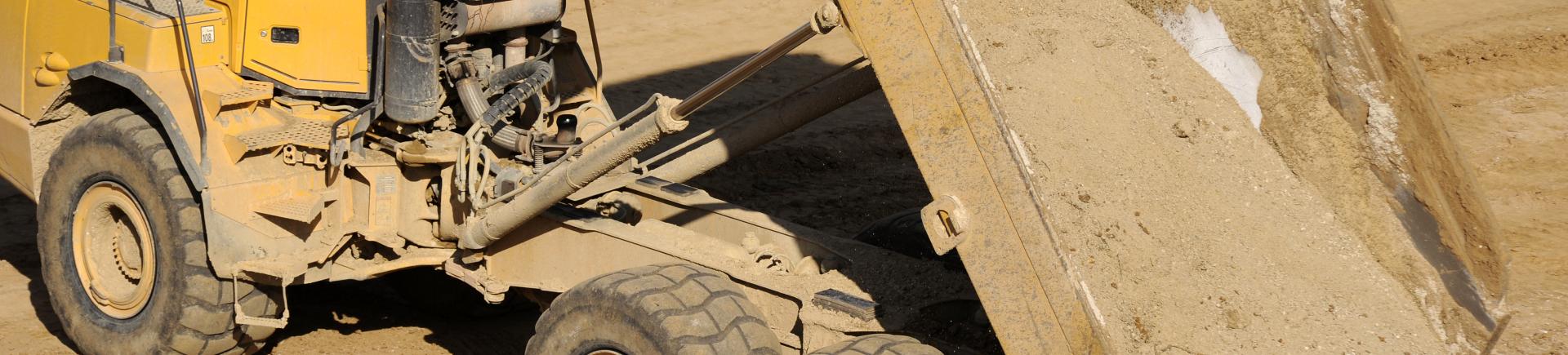 Vue d'un camion benne déversant du sable (France, 2012).